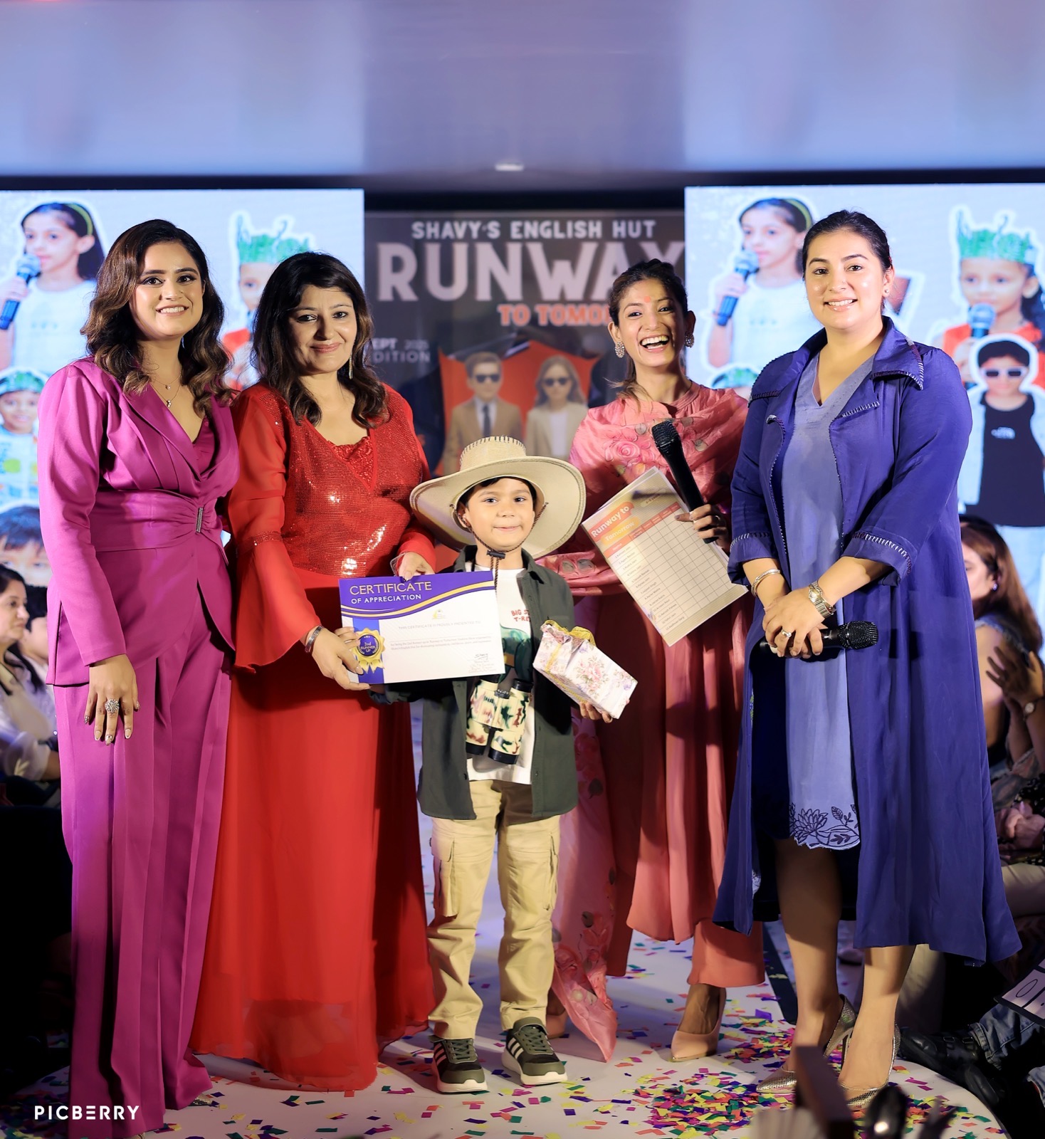 Student receiving a trophy on stage with the SEH team