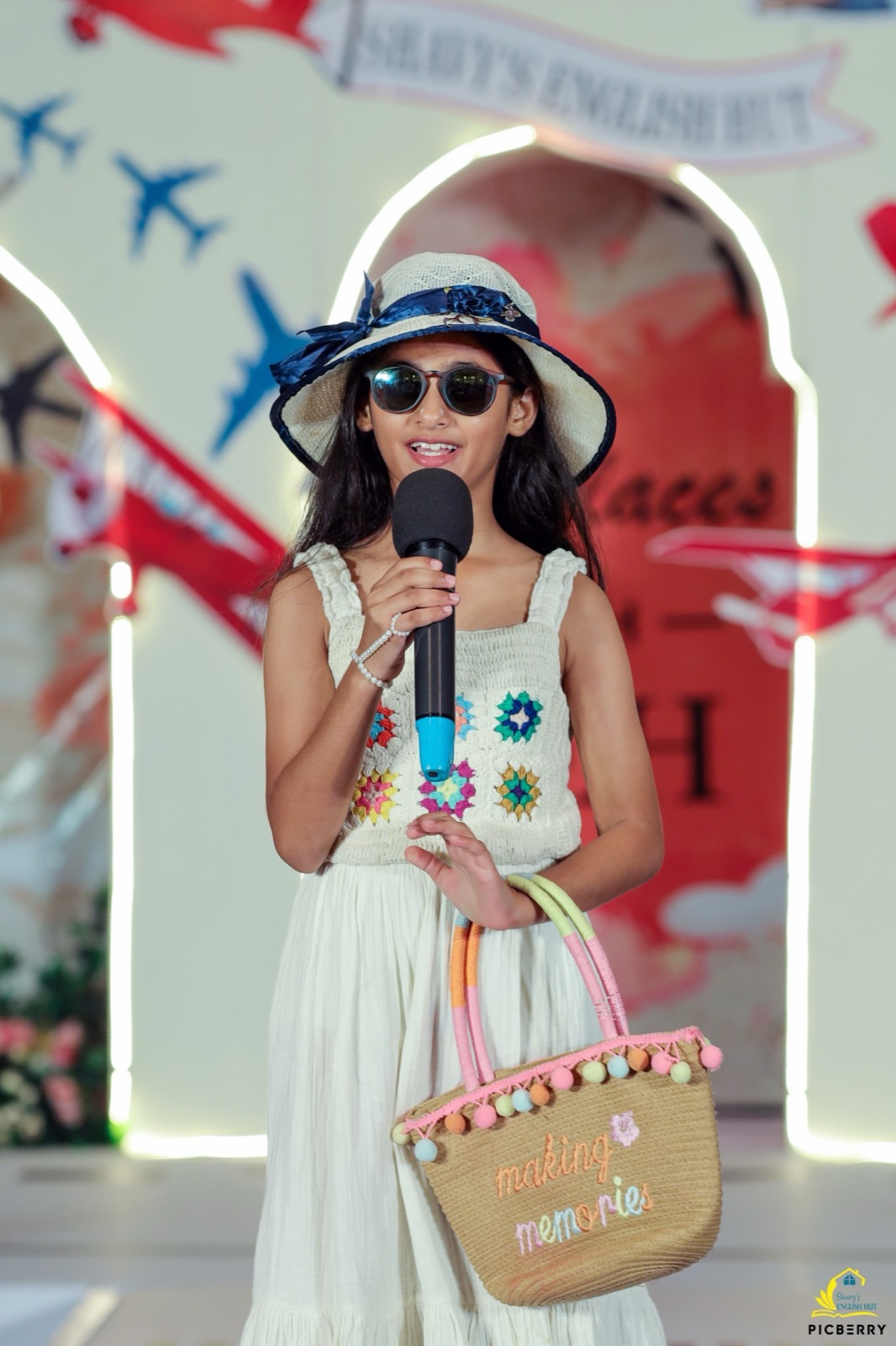 Student speaking on stage holding a bag