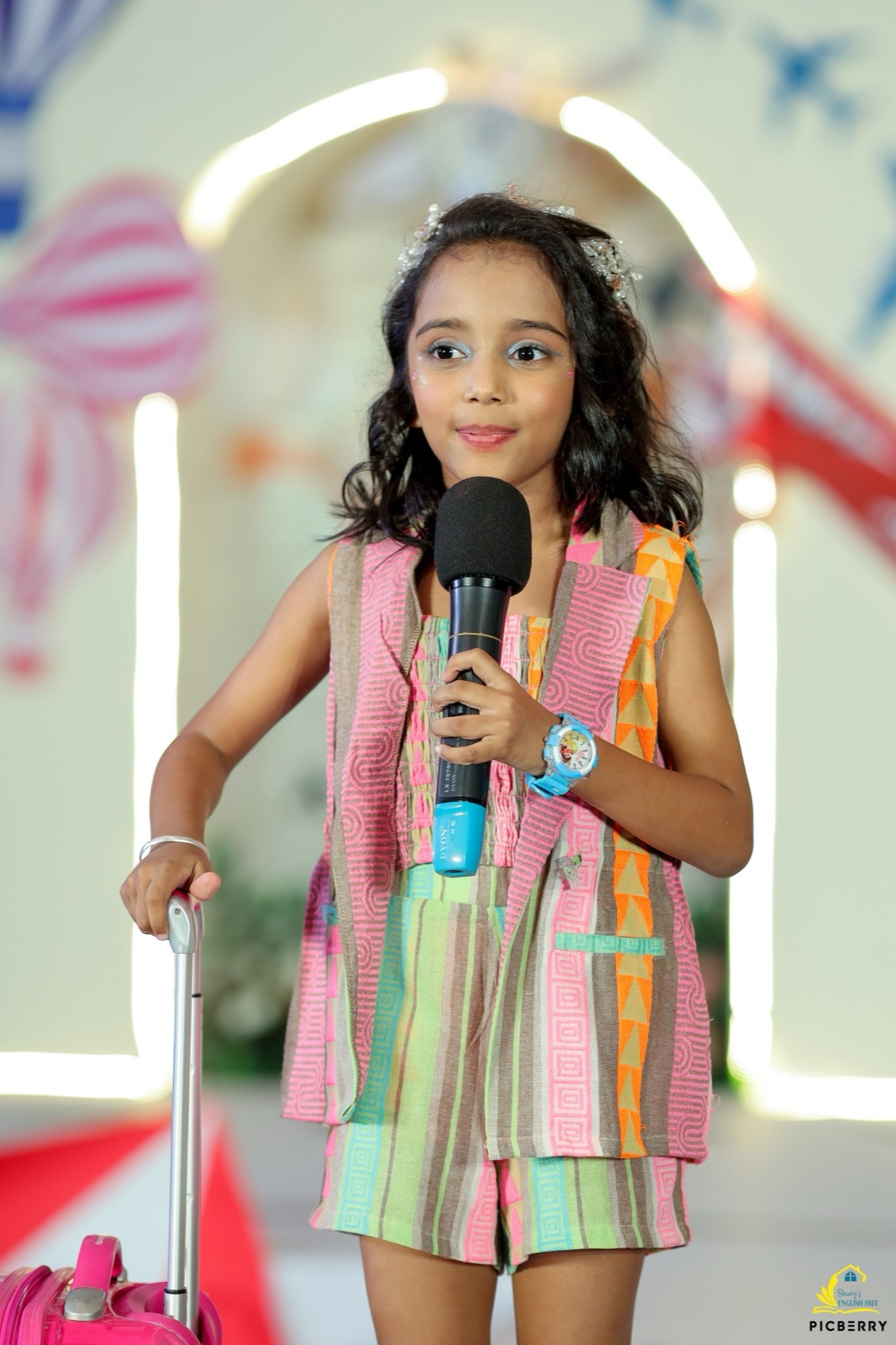 Student holding a microphone on stage at a Shavy's English Hut event